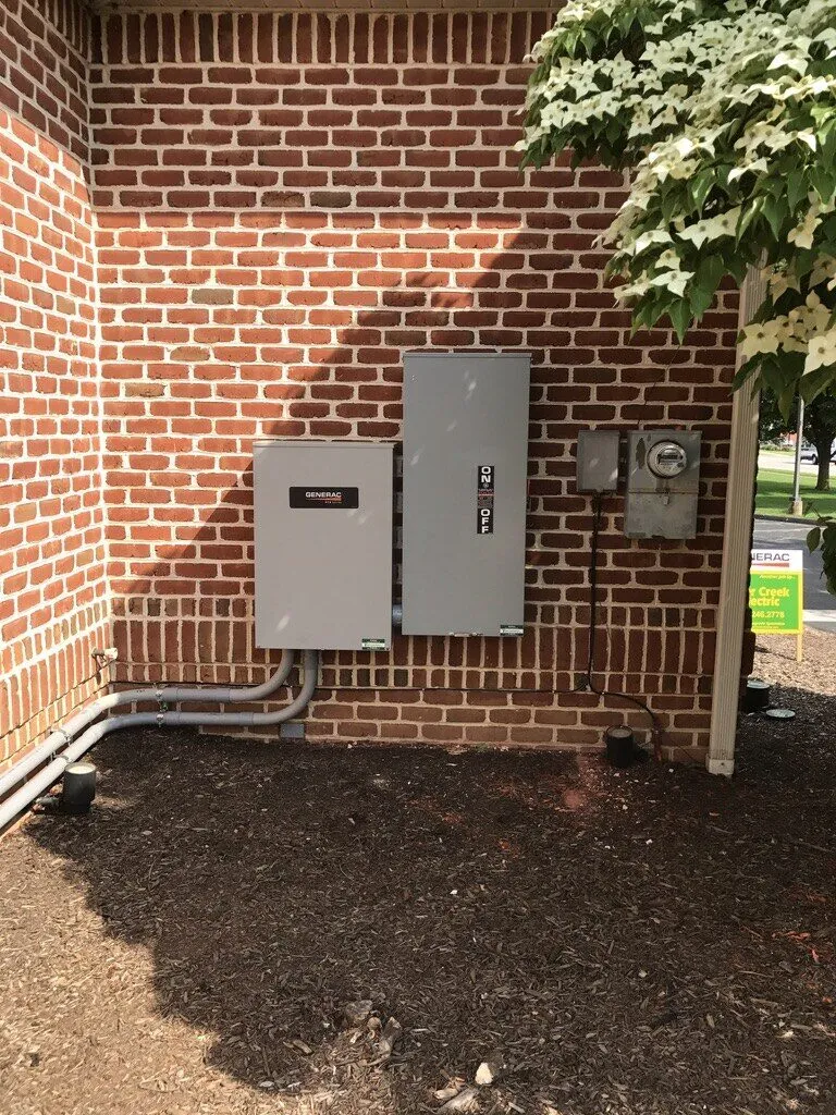 Transfer switch and disconnect mounted on a brick wall next to the electric meter