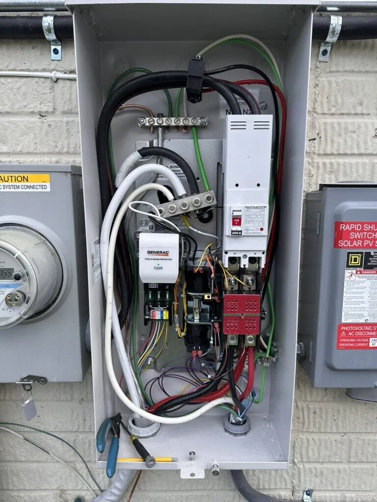 Open outdoor transfer switch enclosure showing new wiring and contactor