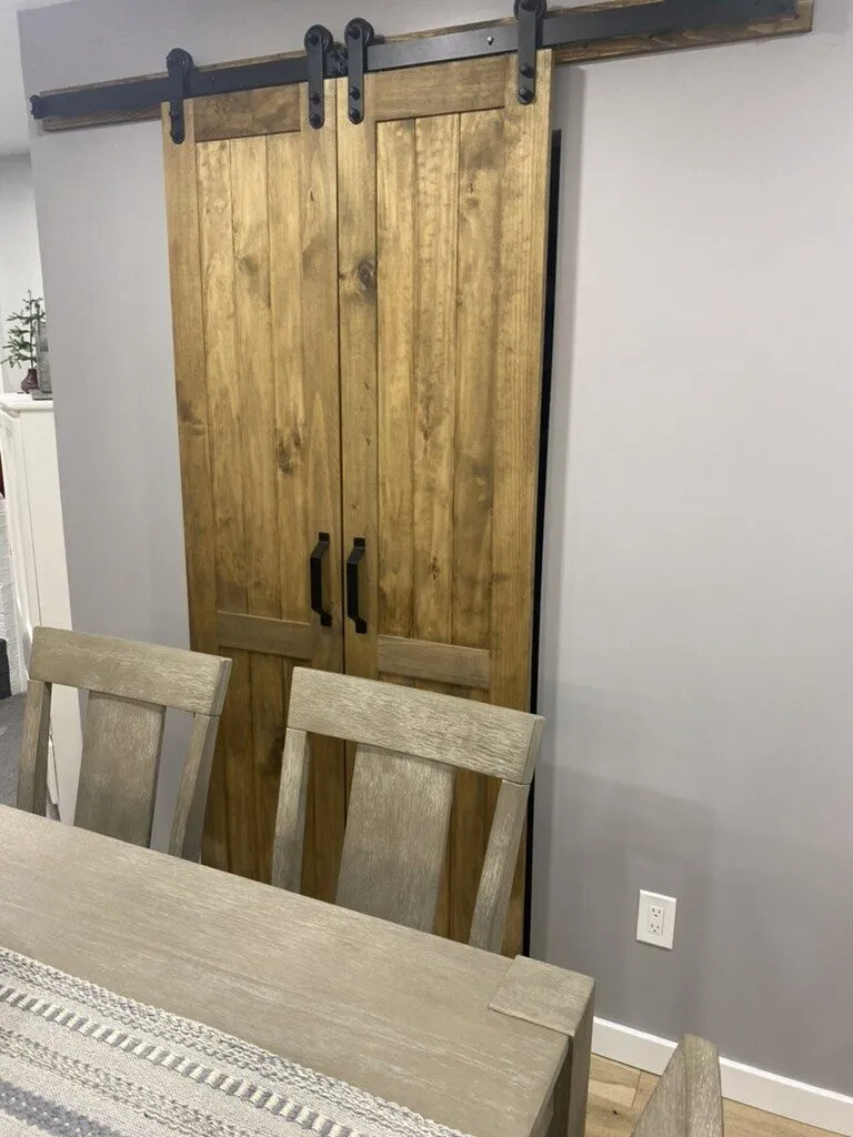 Pair of stained sliding barn doors on a black track