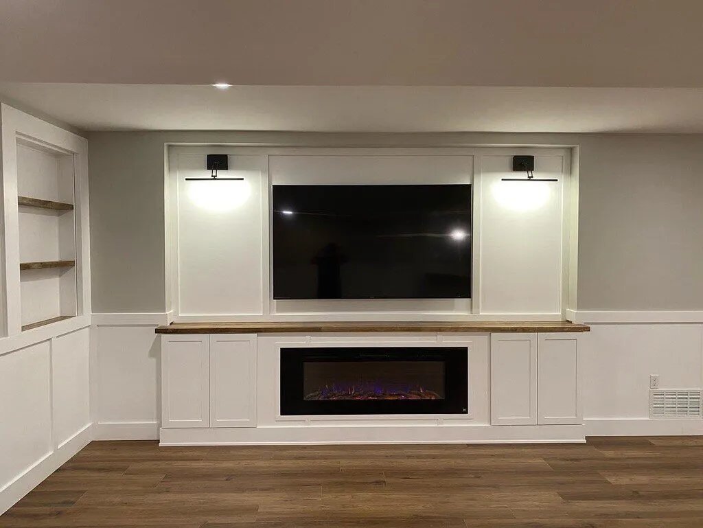 Built-in media wall with cabinets, shelves, a mounted TV and an electric fireplace