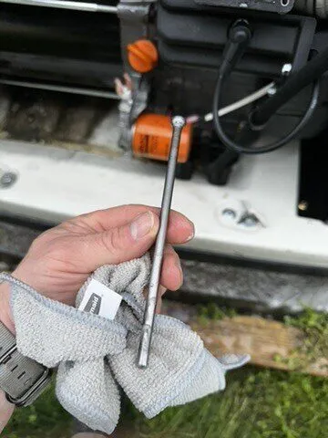 Technician checking a generator engine dipstick with a rag