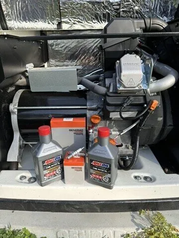 Generator engine compartment open with oil and filters staged for service